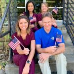Dr. Wiedower, Holly, Jocelyne, and Angie holding small American flags