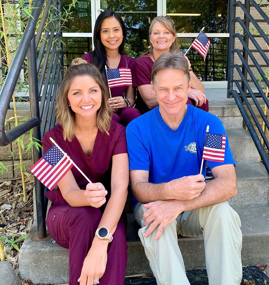 Dr. Wiedower, Holly, Jocelyne, and Angie holding small American flags